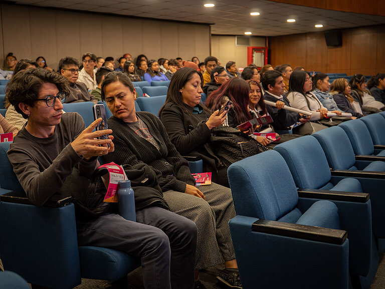 Mehrere Personen sitzen in einem Kinosaal.
