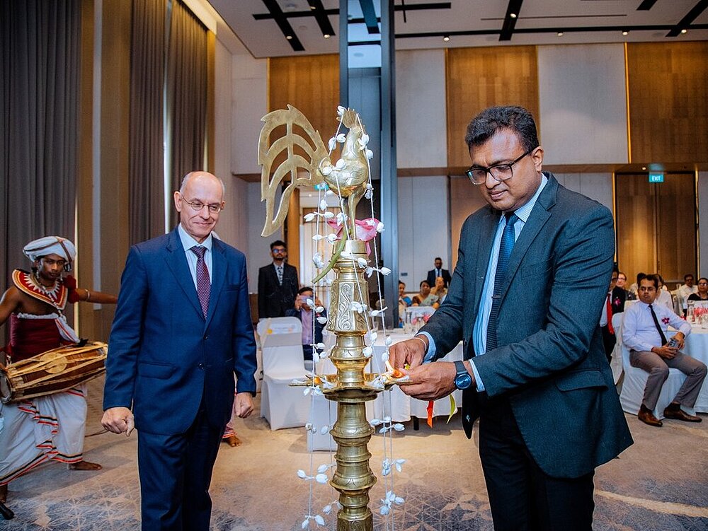 Zwei Männer stehen um eine Statue.