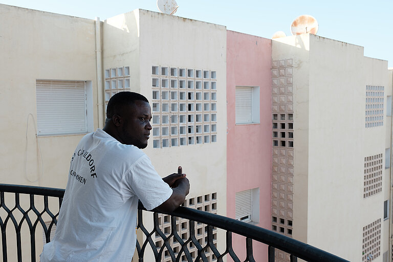 Francis zu Hause in Nour Jaafer. Francis verließ die Elfenbeinküste 2018 in Richtung Tunesien. Er hatte mehrere Jobs (Restaurants, Bau...), bevor er auf einer Baustelle einen Unfall hatte. Heute hat er beschlossen, sich dauerhaft in Tunesien niederzulassen. Um sich besser in die tunesische Gesellschaft zu integrieren, hat er an tunesischen Sprachkursen teilgenommen, die von der Association for Leadership and Development in Africa (ALDA) organisiert wurden. Um seine Lebenssituation zu stabilisieren, ist ihm in erster Linie die Regulierung seines administrativen Status in Tunesien wichtig sowie die Teilnahme am lokalen Leben und am Dialog mit Tunesier*innen. DVV International. ©Augustin Le Gall