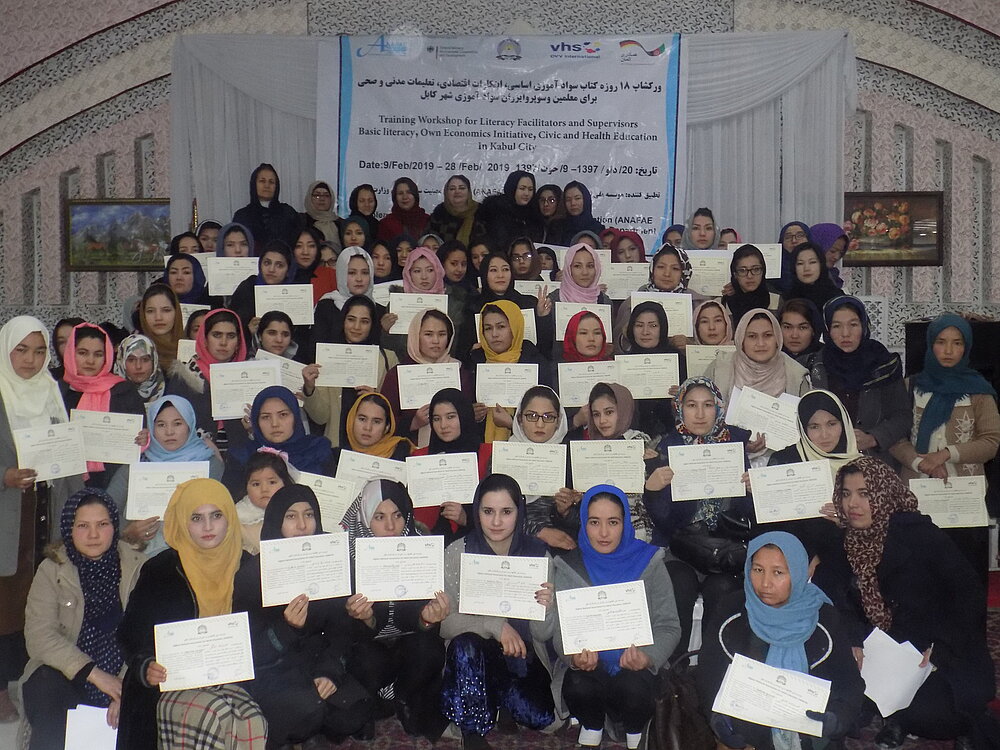 Gruppe von Frauen in Afghanistan, die Zertifikate aus Erwachsenenbildungskursen in der Hand halten 