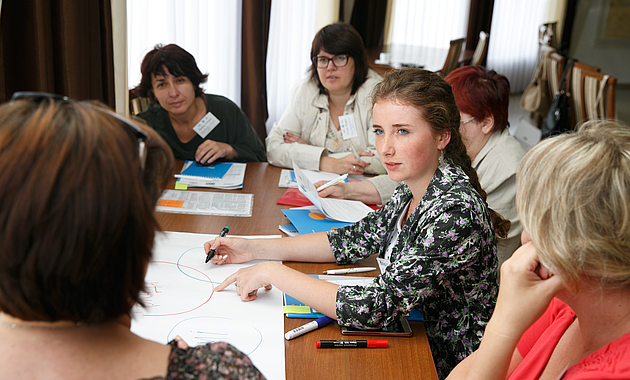 Menschen am Konferenztisch in einer Diskussion