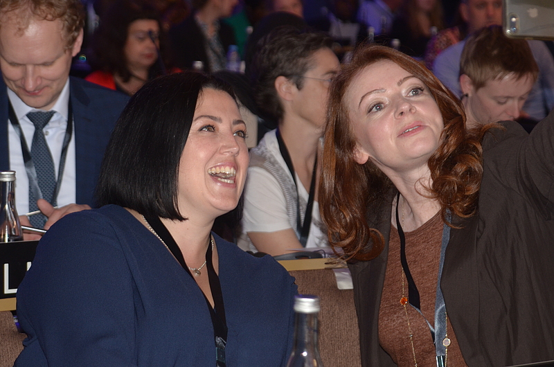 Two women talking and laughing at CONFINTEA VII